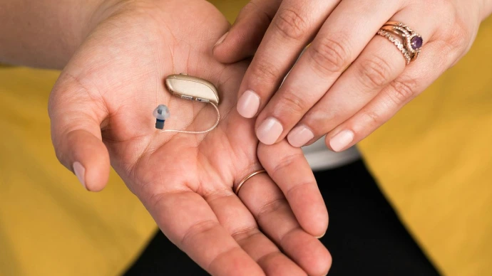 a woman in a yellow shirt holding a pill